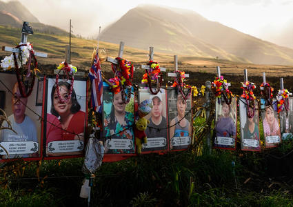 Fotos de fallecidos en los incendios en Hawái bajo cruces blancas en un monumento en memoria de las víctimas de la tragedia de agosto de 2023.