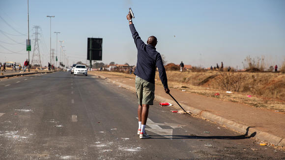 Un vigilante dispara su arma para dispersar a los saqueadores el 14 de julio de 2021 en Johannesburgo, Sudáfrica.